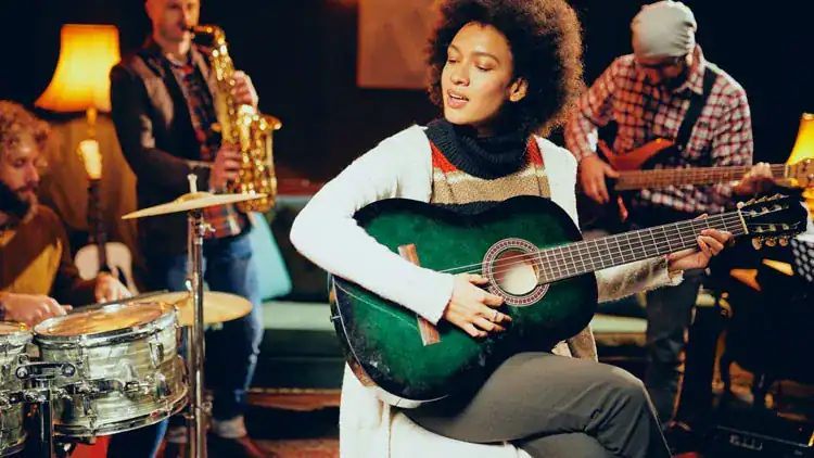A group of musicians playing guitar, saxophone, drums, and bass in a cozy, warmly lit room.